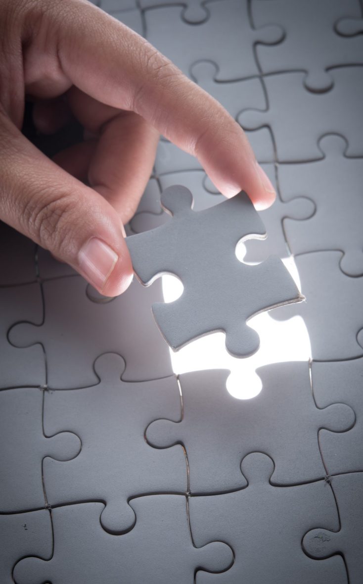 Hand embed missing puzzle piece into place with light glow,success, teamwork and finishing or ending Hand embed missing puzzle piece into place with light glow,success, teamwork and finishing or ending