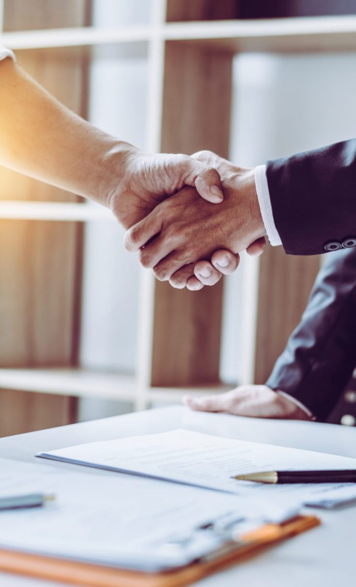 Middle age Asian partner lawyers attorneys shaking hands after discussing a contract agreement done. Middle age partner lawyers attorneys shaking hands after discussing a contract agreement done, Asian people.