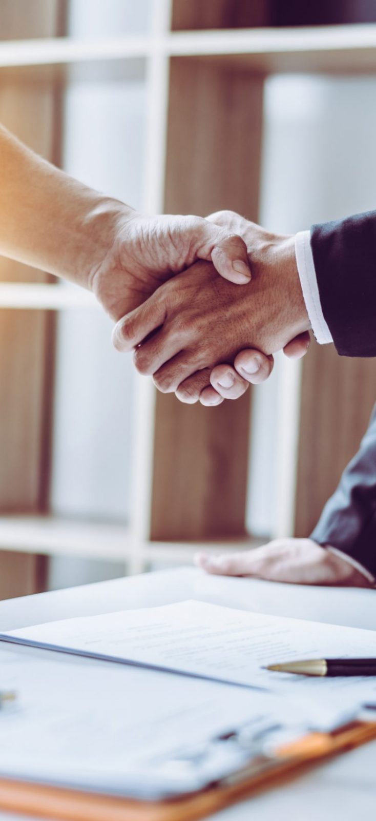 Middle age Asian partner lawyers attorneys shaking hands after discussing a contract agreement done. Middle age partner lawyers attorneys shaking hands after discussing a contract agreement done, Asian people.